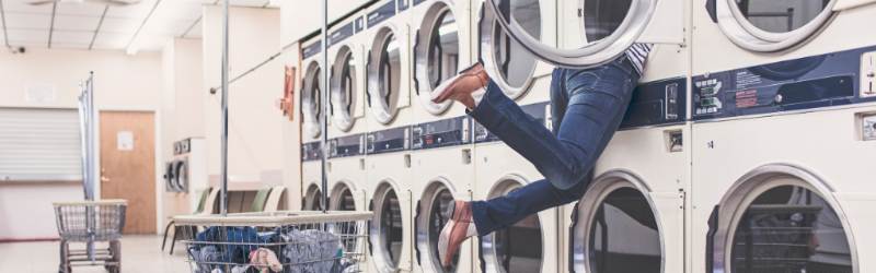 Phot of a person washing clothes in a laundrette