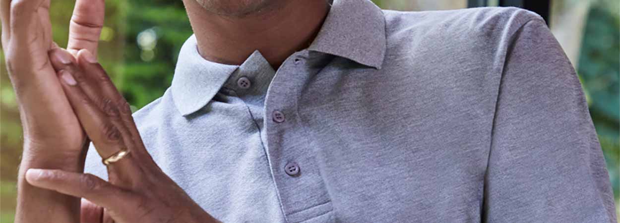 Man wearing a grey polo shirt as part of a workplace uniform
